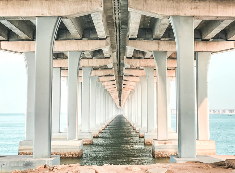 White concrete bridge over blue sea