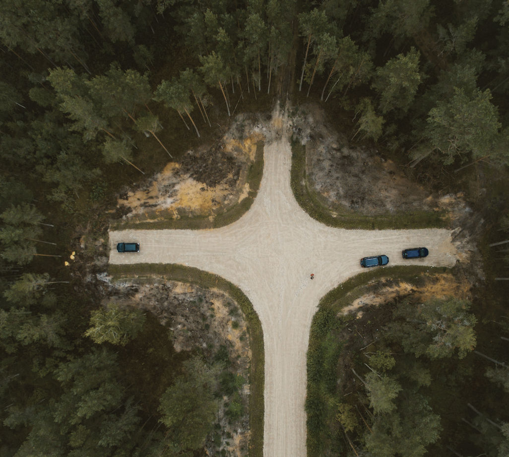 Aerial view of a road through green trees